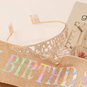 Close-up of rose gold birthday crown and glitter sash with holographic lettering