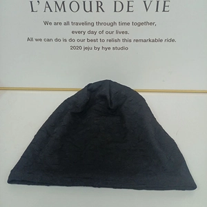 Close-up of black knitted beanie showing textured ribbed pattern and thick warm fabric