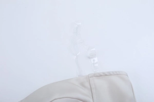 Détail de la bandoulière transparente réglable sur un haut corset en satin dos nu