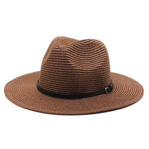 Close-up of brown straw panama hat with textured weave and black buckled leather band
