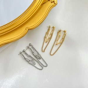 Dual-layer tassel chain earrings in gold and silver finishes on white silk background