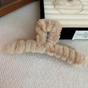 Close-up of khaki plush faux fur hair claw clip with soft texture for winter hairstyles