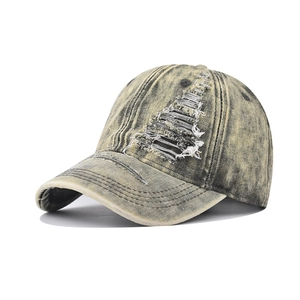 Detail of distressed vintage denim baseball cap with frayed holes and washed texture