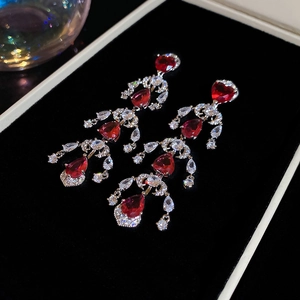 Detailed macro shot of red heart and teardrop tassels on sparkling zircon earrings