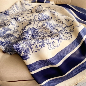 Blue and white French Toile de Jouy silk scarf draped on a vintage chair