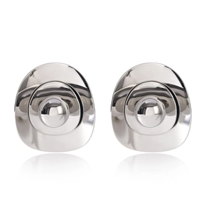 Close-up of silver earrings with irregular concentric circles and polished mirror finish