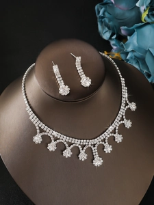 Detail of luxury silver rhinestone fringe necklace and long earrings set on display