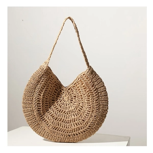 Detail of hand-woven straw shoulder bag showing natural plant fiber texture and pattern