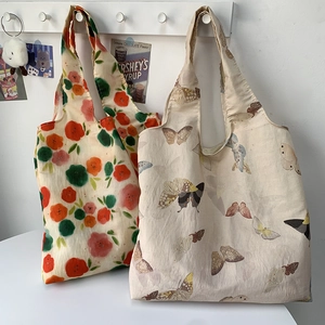 Detailed view of canvas tote bags featuring floral and vintage butterfly prints