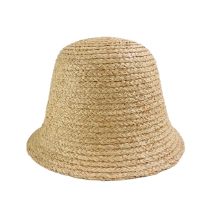 Natural raffia straw bucket hat with a bell-shaped design and tight woven texture