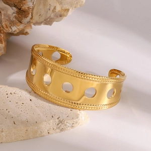 Detailed macro view of a gold hollow-out wide cuff bracelet with rope texture edges