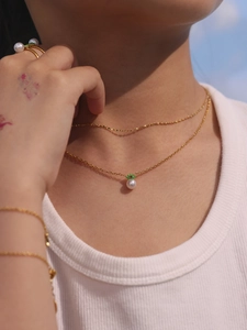 Close-up of a double-layer gold crown pearl necklace on a model with blue sky background