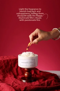 Lighting a floral relief aromatherapy candle in a ceramic jar with wooden base