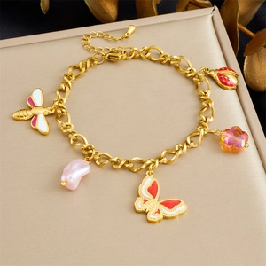 Detailed view of a gold chain bracelet with enamel butterflies and floral charms