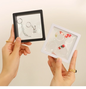 Transparent PE film jewelry suspension box showing ring and earrings held by hand