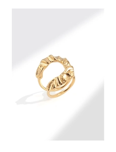 Detailed view of golden irregular pleated wide ring with modern wavy texture and shadows