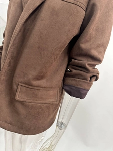 Macro detail of brown suede blazer texture featuring notch lapel and oversized flap pocket