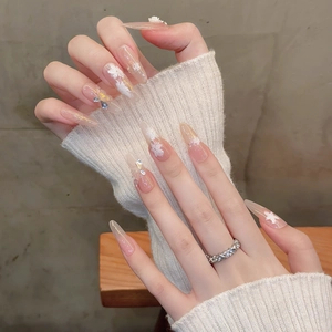 Faux ongles amande longs avec fleurs 3D, feuilles d'or et paillettes sur base rose nude