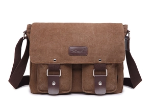 Close-up of dual front pockets and leather magnetic buckle on brown canvas messenger bag
