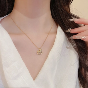 Detail einer vergoldeten Pony-Halskette mit kleinen Diamanten am Hals des Models
