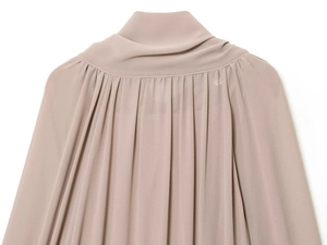 Detalle del elegante cuello con lazo y pliegues de gasa en un vestido rosa palo