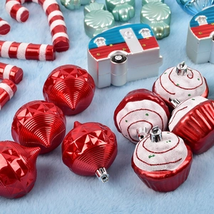 Assorted Christmas tree ornaments featuring painted red baubles, camper and cupcake shapes