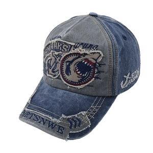 Detail of vintage shark embroidery and distressed denim patchwork on baseball cap