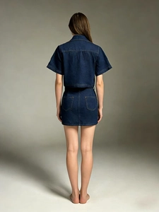 Rear view of deep blue denim set showing detailed stitching and fabric texture on a model