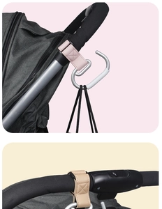Macro shot of pink and beige leather stroller hooks with silver metal carabiner detail