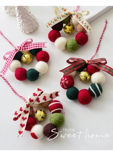 Details von vier handgefertigten Weihnachtskränzen aus Wollfilz mit Glöckchen und Bändern