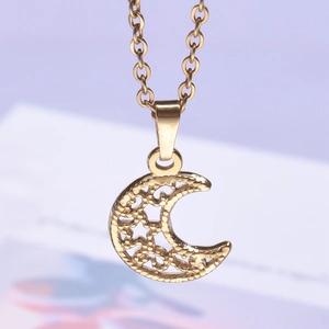 Macro shot of gold moon pendant with intricate hollow patterns and fine golden texture