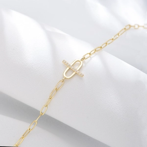 Macro detail of gold paperclip chain bracelet with shimmering micro-pave cubic zirconia