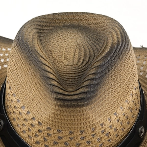 Macro view of woven straw cowboy hat with vintage burnt finish and star rivet band