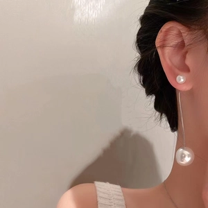 Close-up of elegant 925 silver long tassel earrings with lustrous white pearls on a model