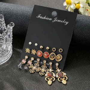 Detail of 9-pair earring set with faux pearls and colorful gemstones on black display card