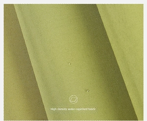 Detail of high-density water-repellent umbrella fabric in mustard green with water droplets
