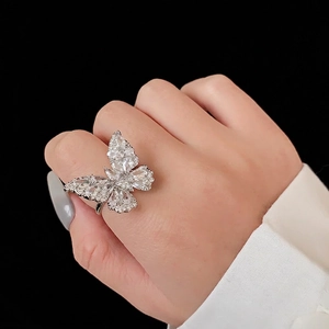 Bague papillon argentée élégante avec pavé de zircons sur un fond noir intense