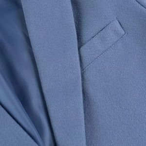 Detail shot of blue wool jacket collar and textured pocket showing fine craftsmanship