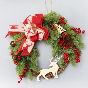 Christmas wreath with pine needles, red berries, pine cones and a deer ribbon bow
