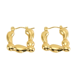 Macro shot of gold-plated stainless steel irregular wavy hoop earrings with a mirror finish