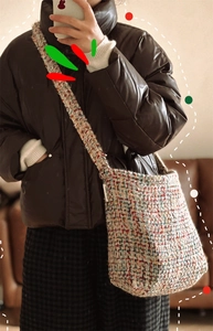 Detail of multi-color tweed woven crossbody bag with textured fabric and side fabric label