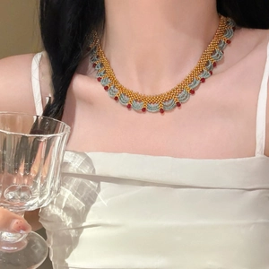 Détail du collier ras du cou en perles de cristal dorées, bleues et rouges fait main