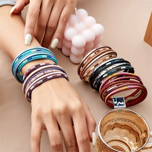 Détail de bracelets multicouches en cuir et perles avec fermoirs magnétiques colorés