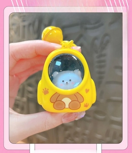 Close-up of yellow bear backpack keychain with transparent window and mini bear charm inside