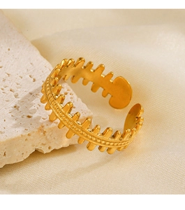 Detail of adjustable 18K gold plated fishbone ring on a luxury fabric and stone backdrop