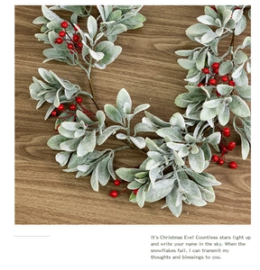 Detail of frosted lamb ear leaves and red berries on a rustic wooden tabletop