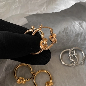 Orecchini a cerchio annodati minimalisti in oro e argento dal design moderno e lucido