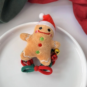 Détail d'un chouchou en peluche bonhomme en pain d'épice avec élastique rouge et vert