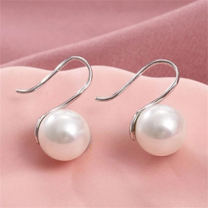 Elegant S925 sterling silver pearl drop earrings on soft pink silk background