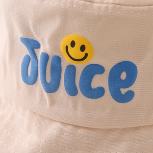 Detailansicht des blauen Juice-Schriftzugs und gelben Smileys auf dem beigen Baumwoll-Fischerhut